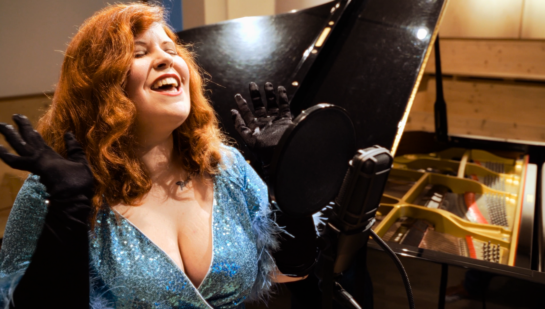 Singer songwriter Cecilya Mestres delivering a glamorous vocal performance by an elegant grand piano in an official music video.
