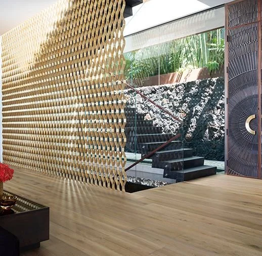 Modern interior with a geometric partition, staircase, indoor rock wall, and tropical greenery
