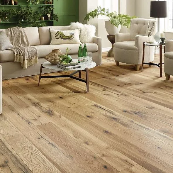 Bright living room with wide-plank natural oak flooring, beige furniture, green plants, and a modern coffee table