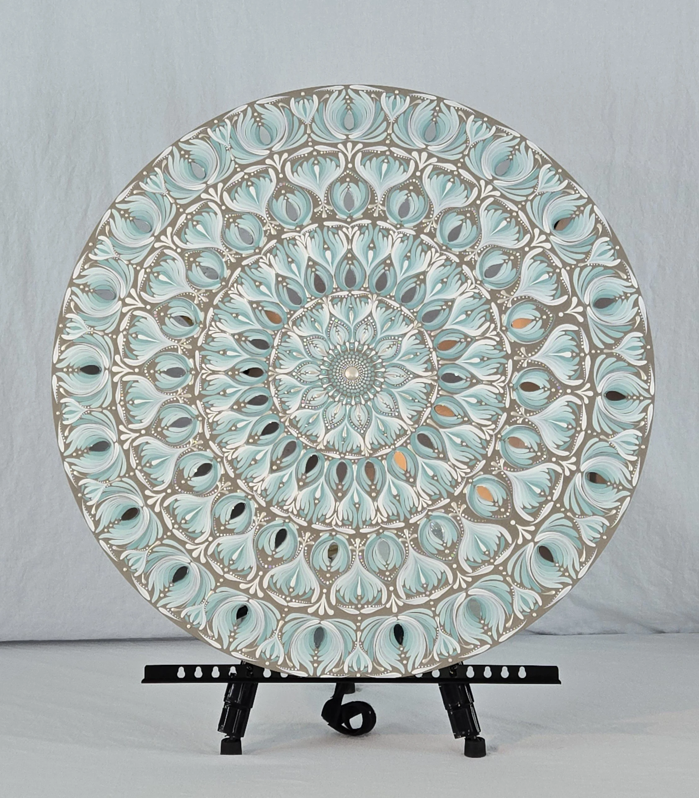 Large aqua and gold mandala artwork mounted above the headboard of a neutral luxury bedroom set.