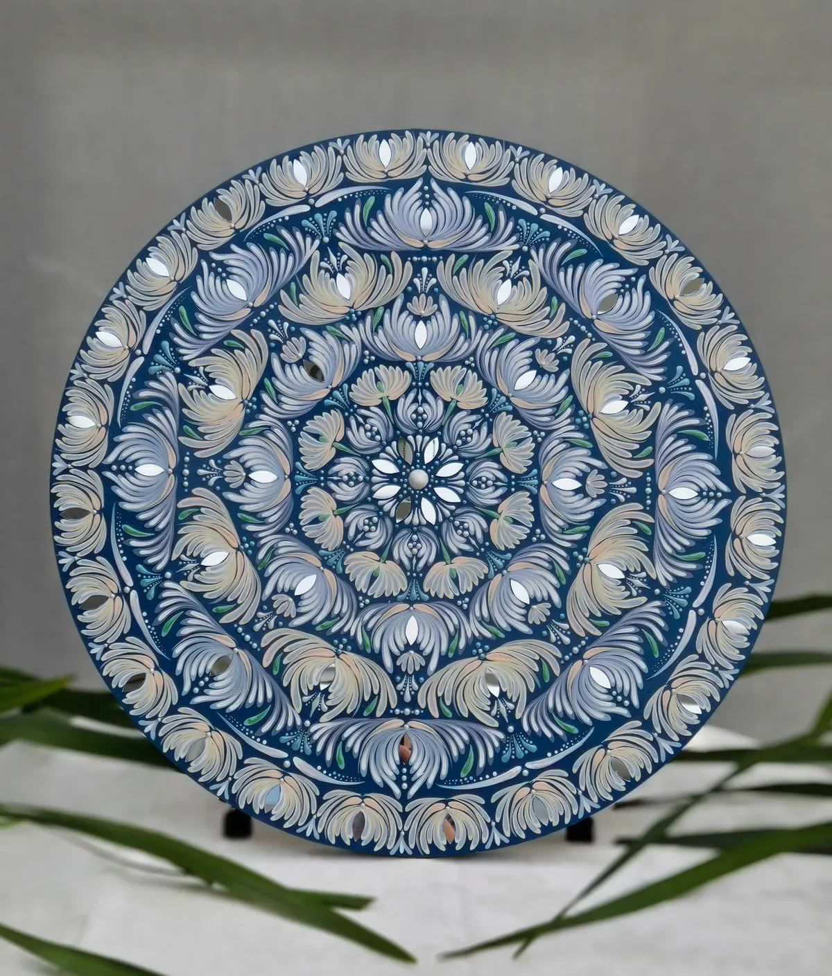 Hand-painted mandala wall art on a 24-inch round birch wood canvas featuring ivory and silver-blue blossoms on a midnight-blue background.
