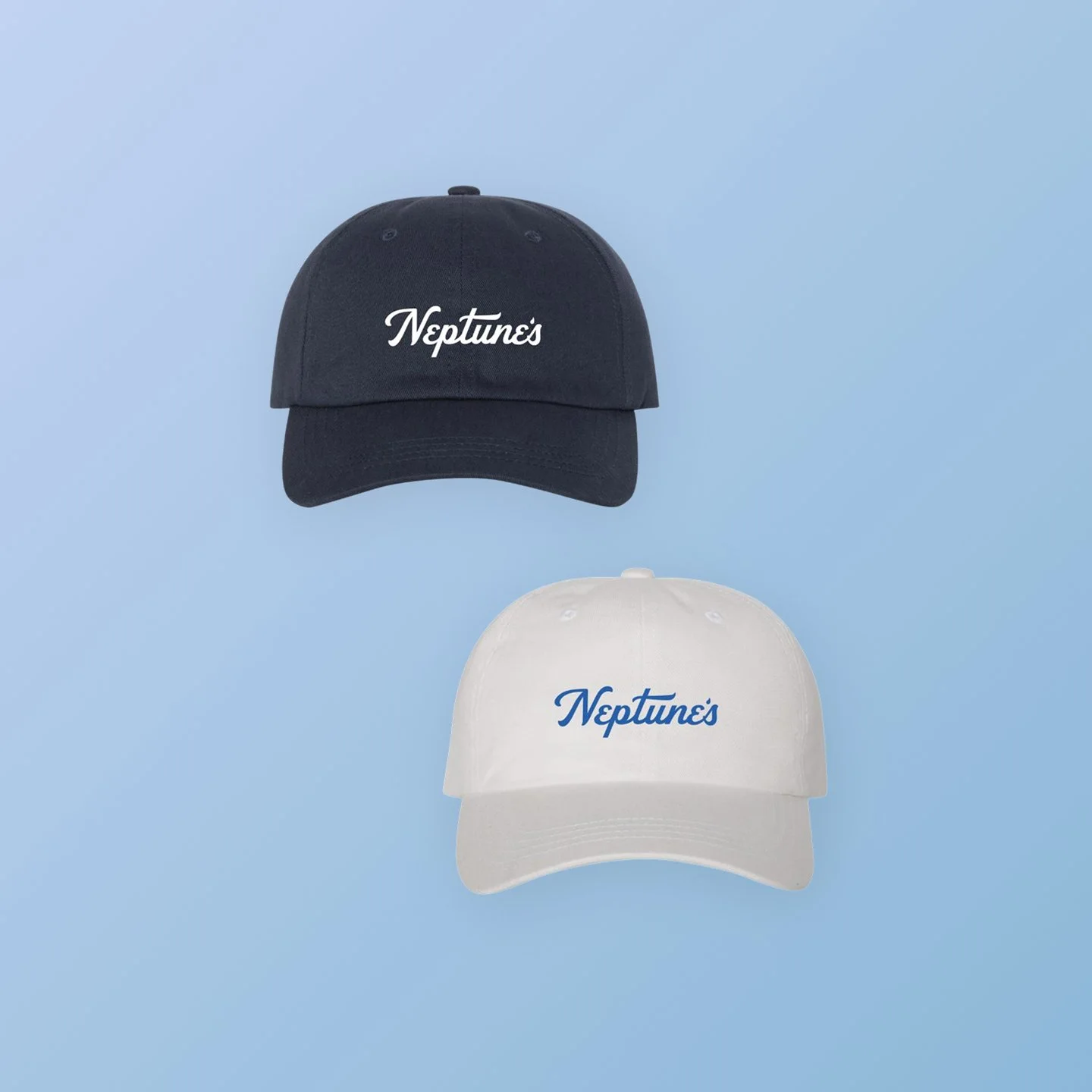 Two baseball caps, one black with white embroidered text and one white with blue embroidered text, against a blue background.