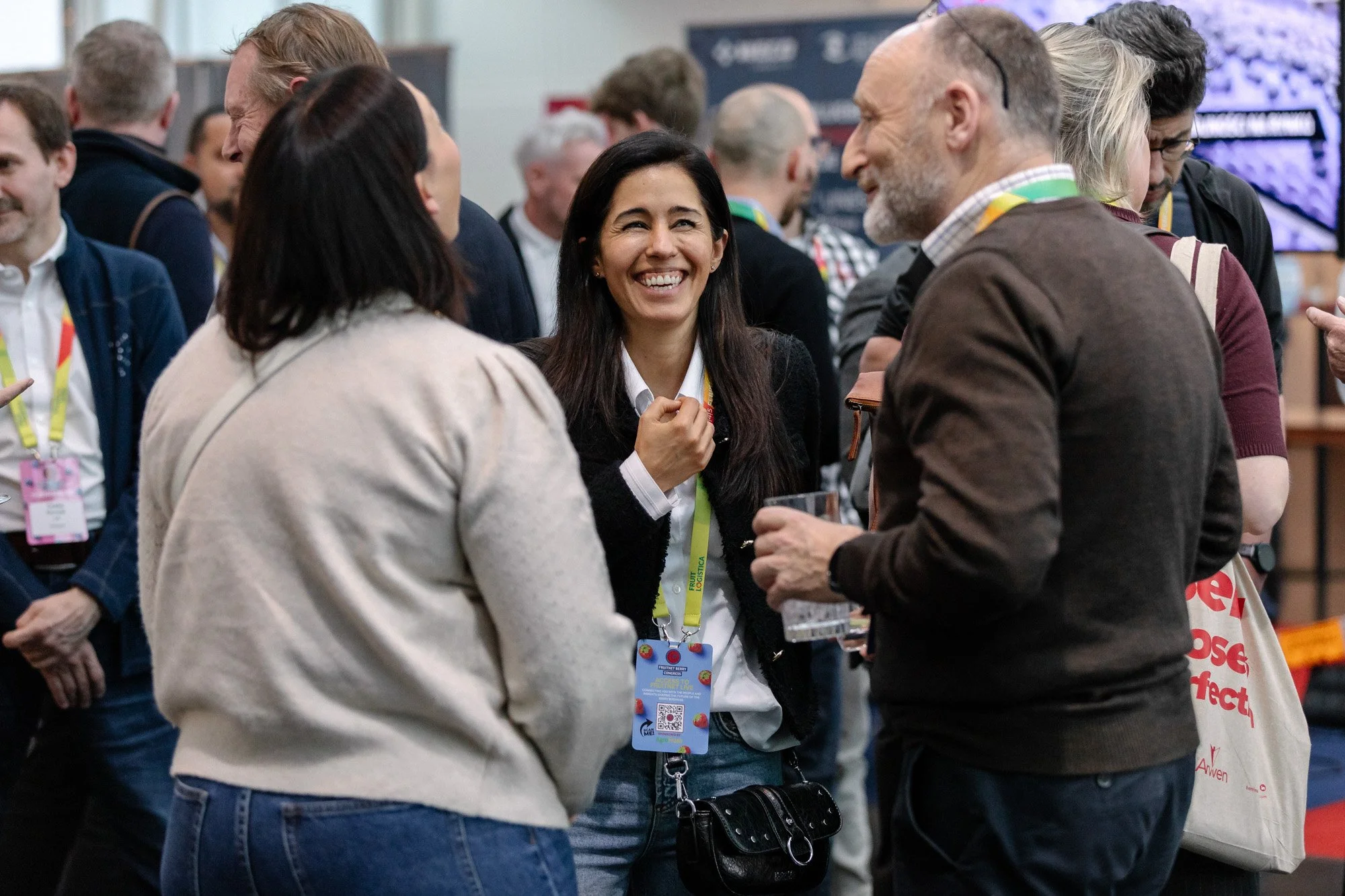 A smiling delegate chatting with a group during a conference break.