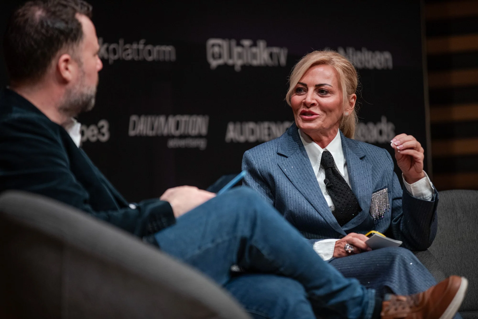 Two panellists in conversation, photographed over one speaker’s shoulder.