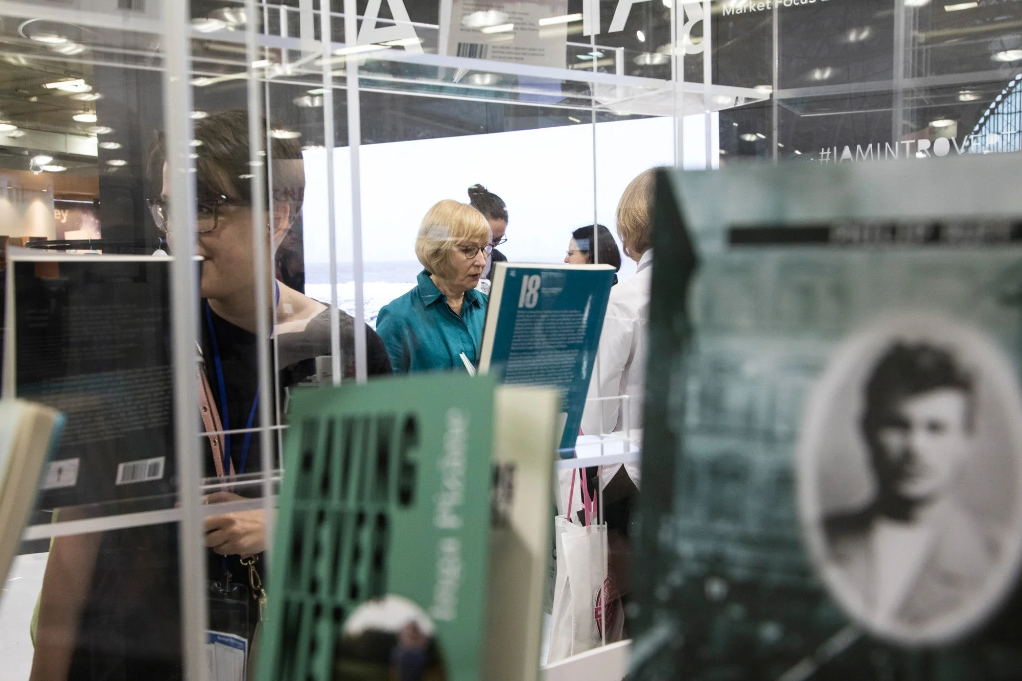 Visitors talking among book displays at the Pop Up Creators Book Fair.