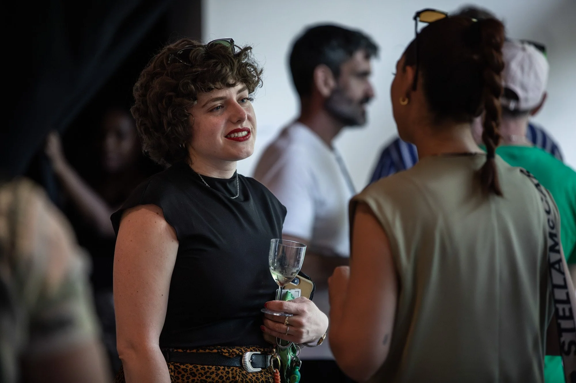 Guests chatting over drinks at the Locus of Voices exhibition reception.