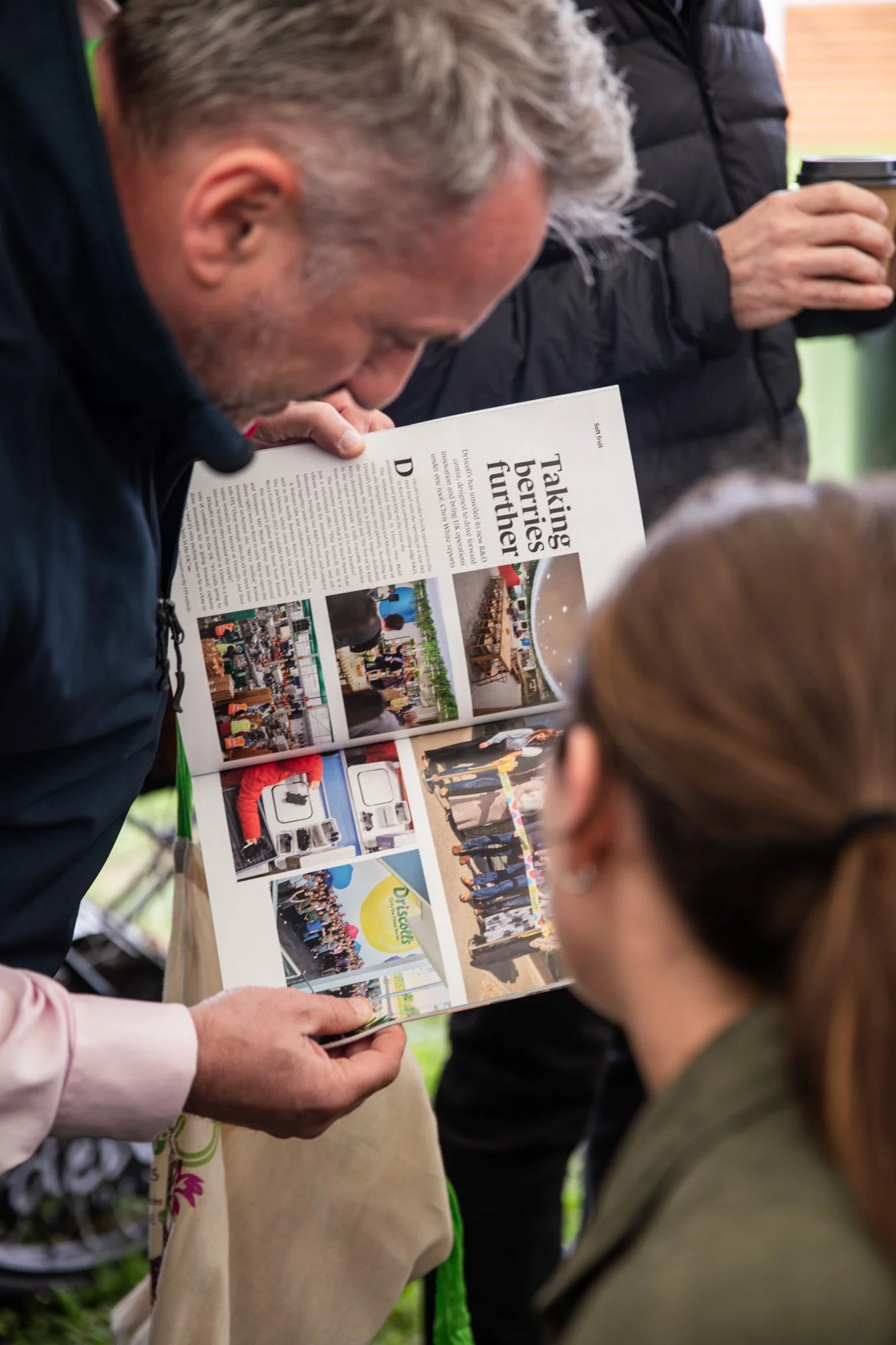Visitors looking through an exhibitor's brochure at Festival of Fresh.