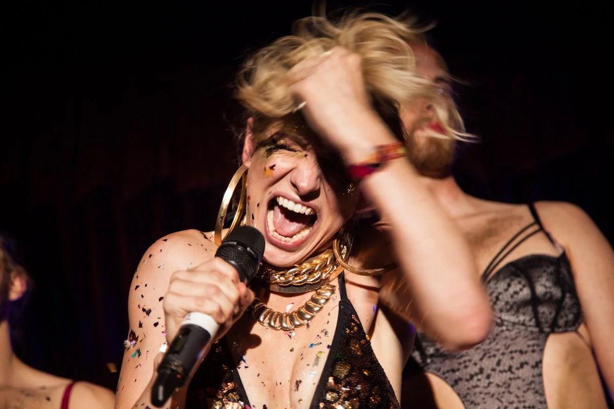 Close-up of a singer holding a microphone during a live performance.