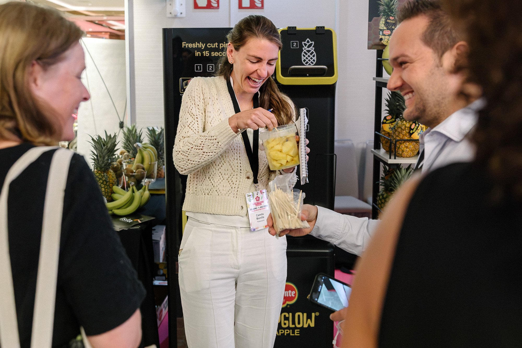 Visitors chatting over pineapple drinks at an exhibition stand at Tropicals Congress.