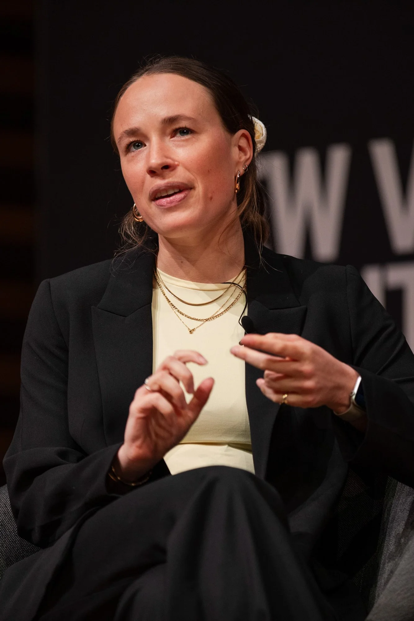 A woman in a black blazer gesturing during a panel discussion at New Video Frontiers.