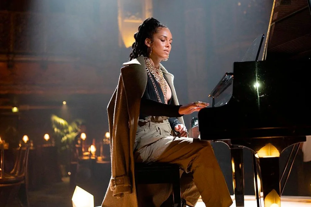 A woman playing the piano in a dimly lit, cozy room.