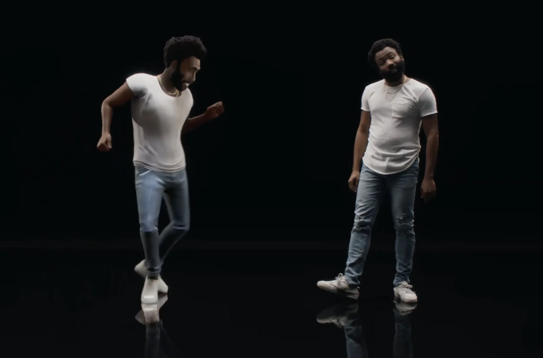Two men wearing white t-shirts and jeans are dancing or performing on a black background with a reflective floor.