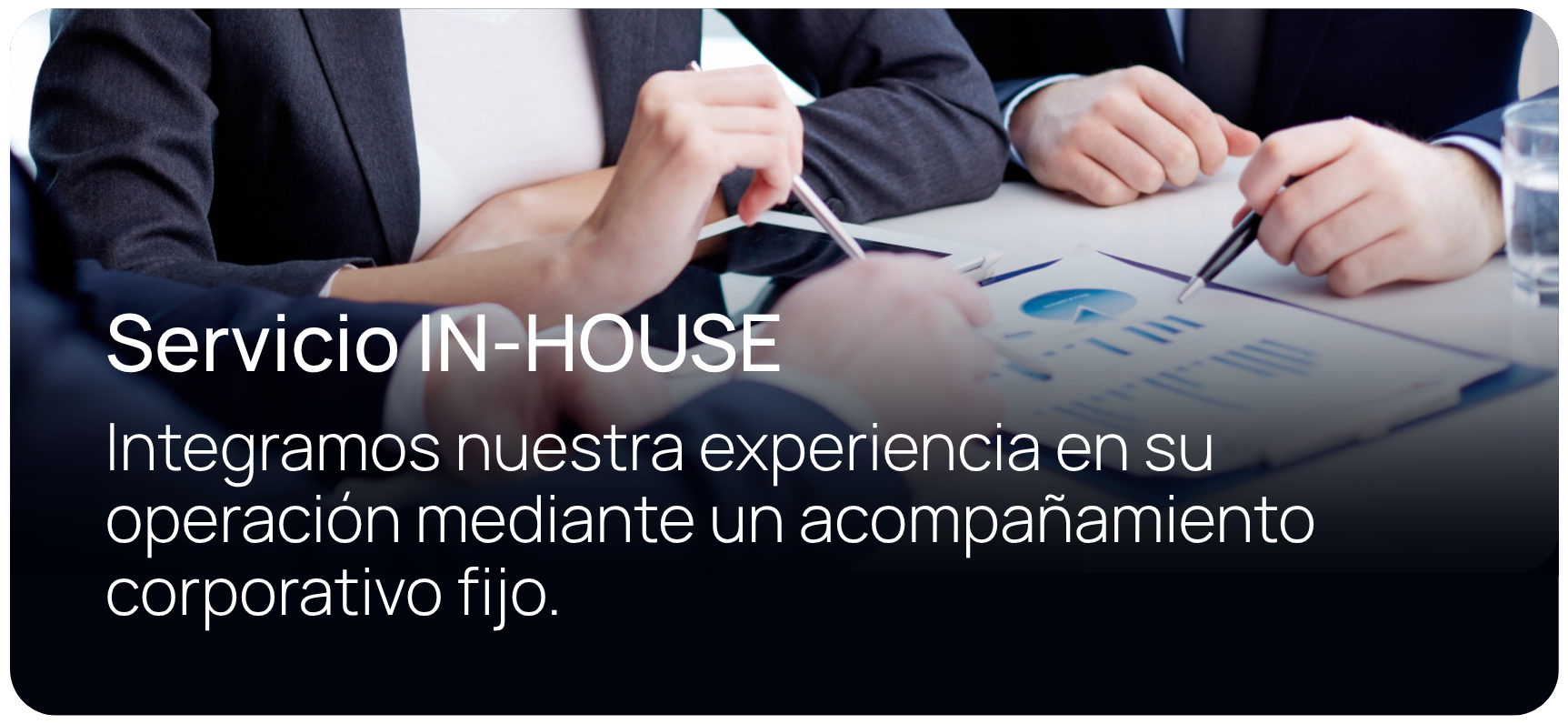 Personas de negocios en una reunión revisando gráficos y documentos en una mesa.