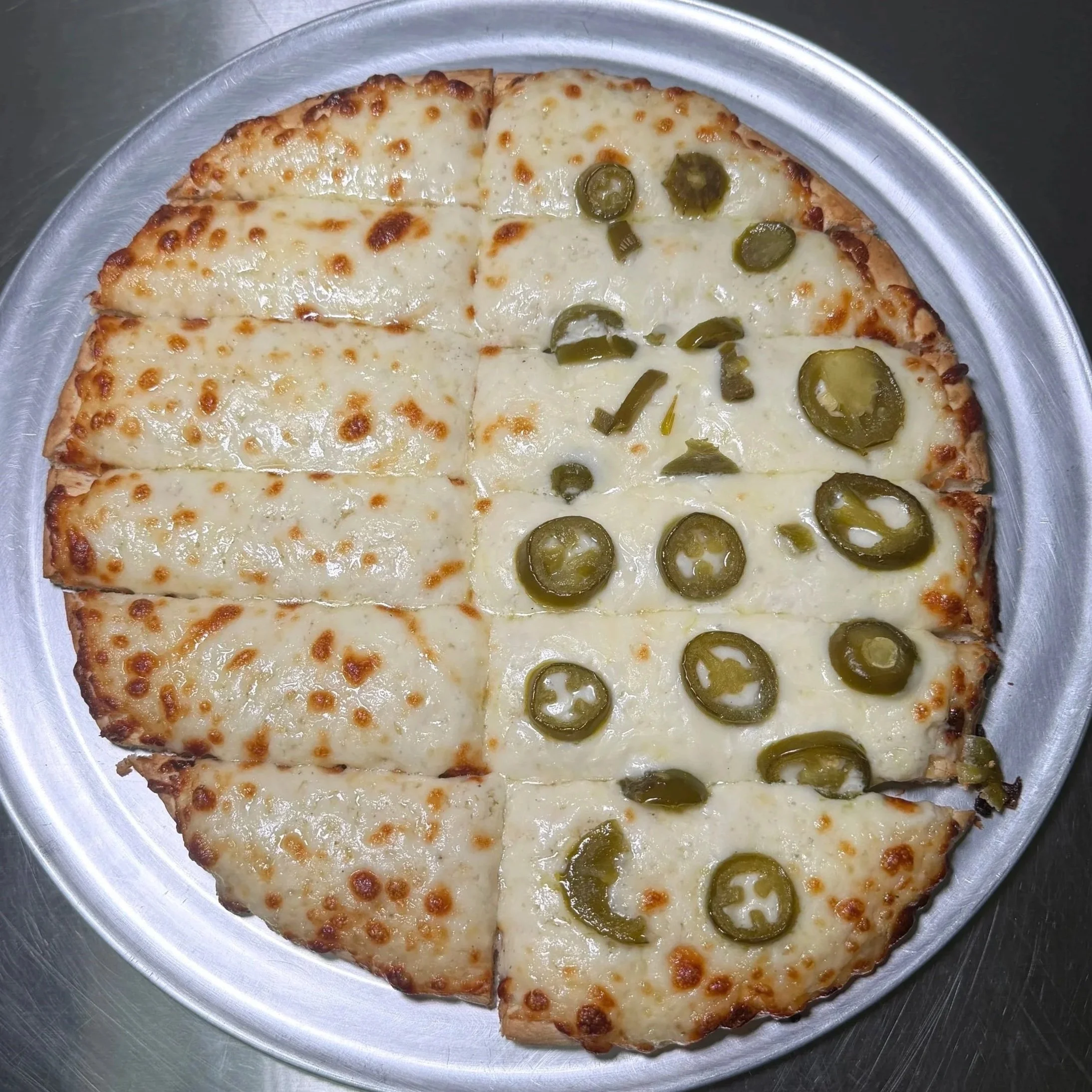 Cheese pizza with jalapeño slices on a silver tray