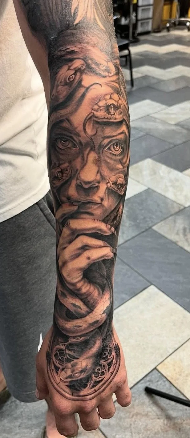 Black and grey realism medusa tattoo on a forearm by Altered Tattoo Co