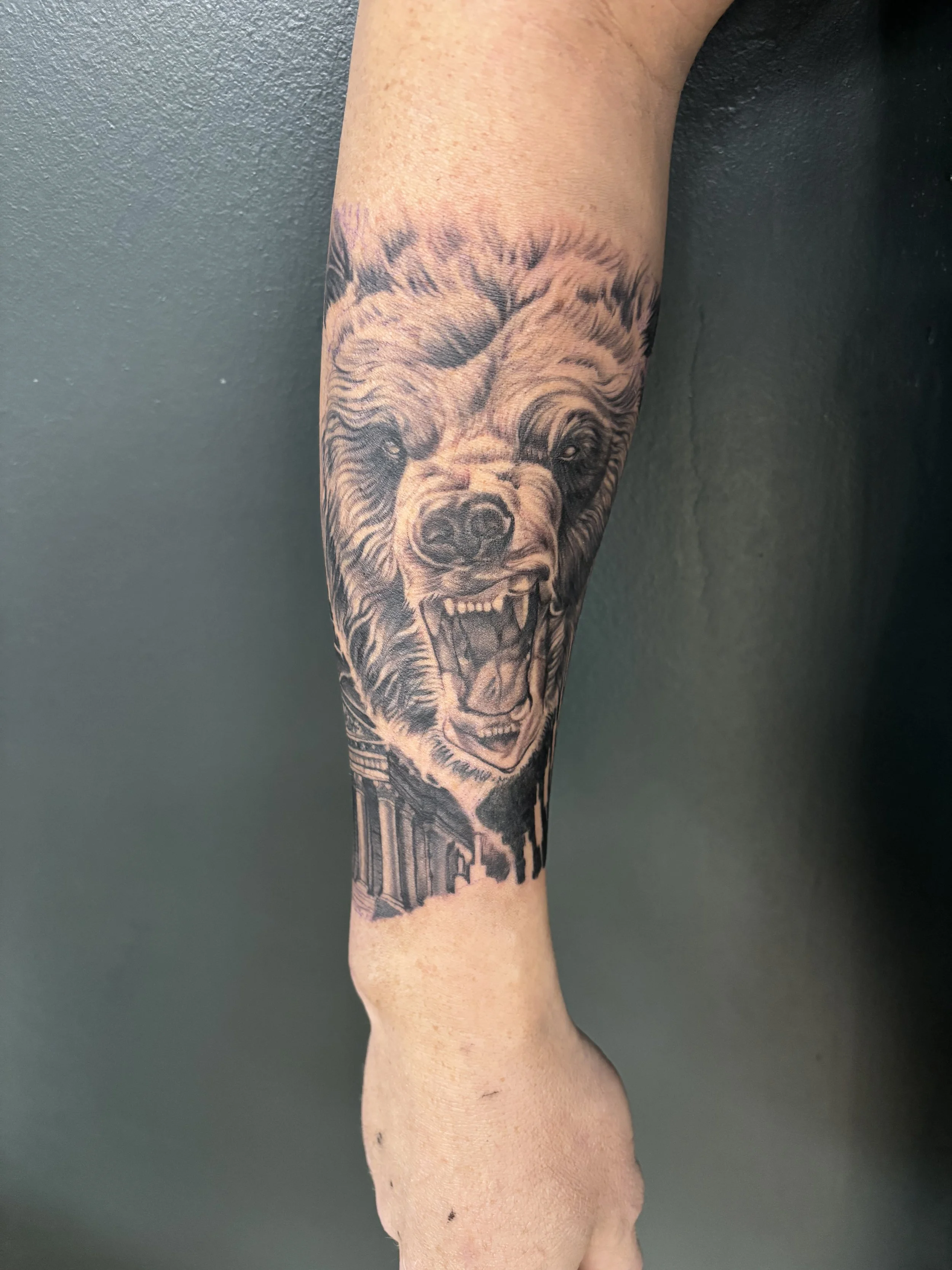 Crypto inspired black and grey realism tattoo of a bear on a forearm by Altered Tattoo Co