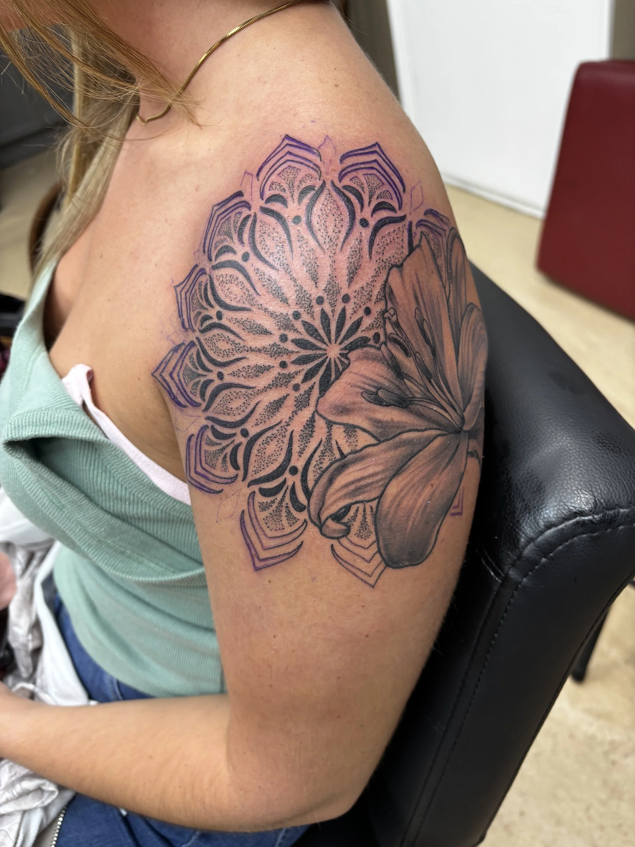 Black and gey realism lily and geometric mandala tattoo on a shoulder by Altered Tattoo Co