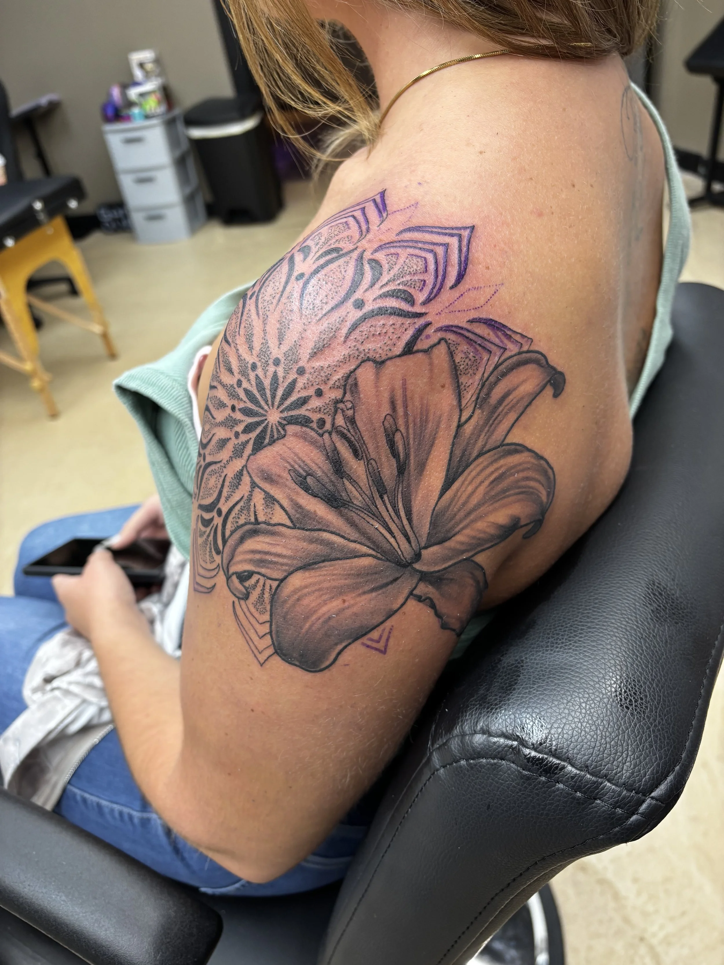 Black and gey realism lily and geometric mandala tattoo on a shoulder by Altered Tattoo Co