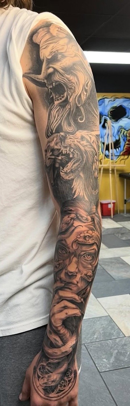 Black and grey realism cerberus tattoo on a bicep by Altered Tattoo Co