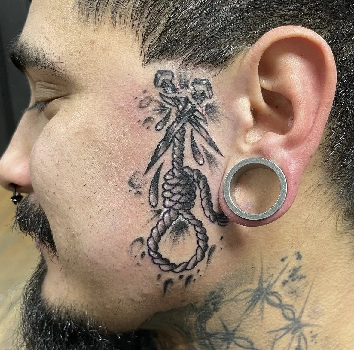 Neo Traditional black and grey noose and cutnails tattoo on a face by Altered Tattoo Co