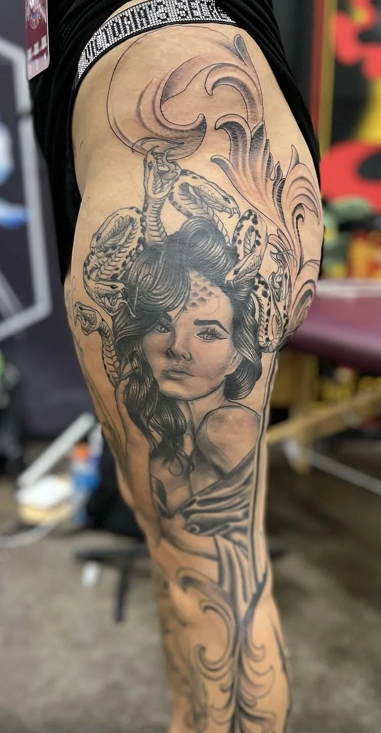 Black and grey realism and neo traditional mashup medusa tattoo on womans thigh by Altered Tattoo Co