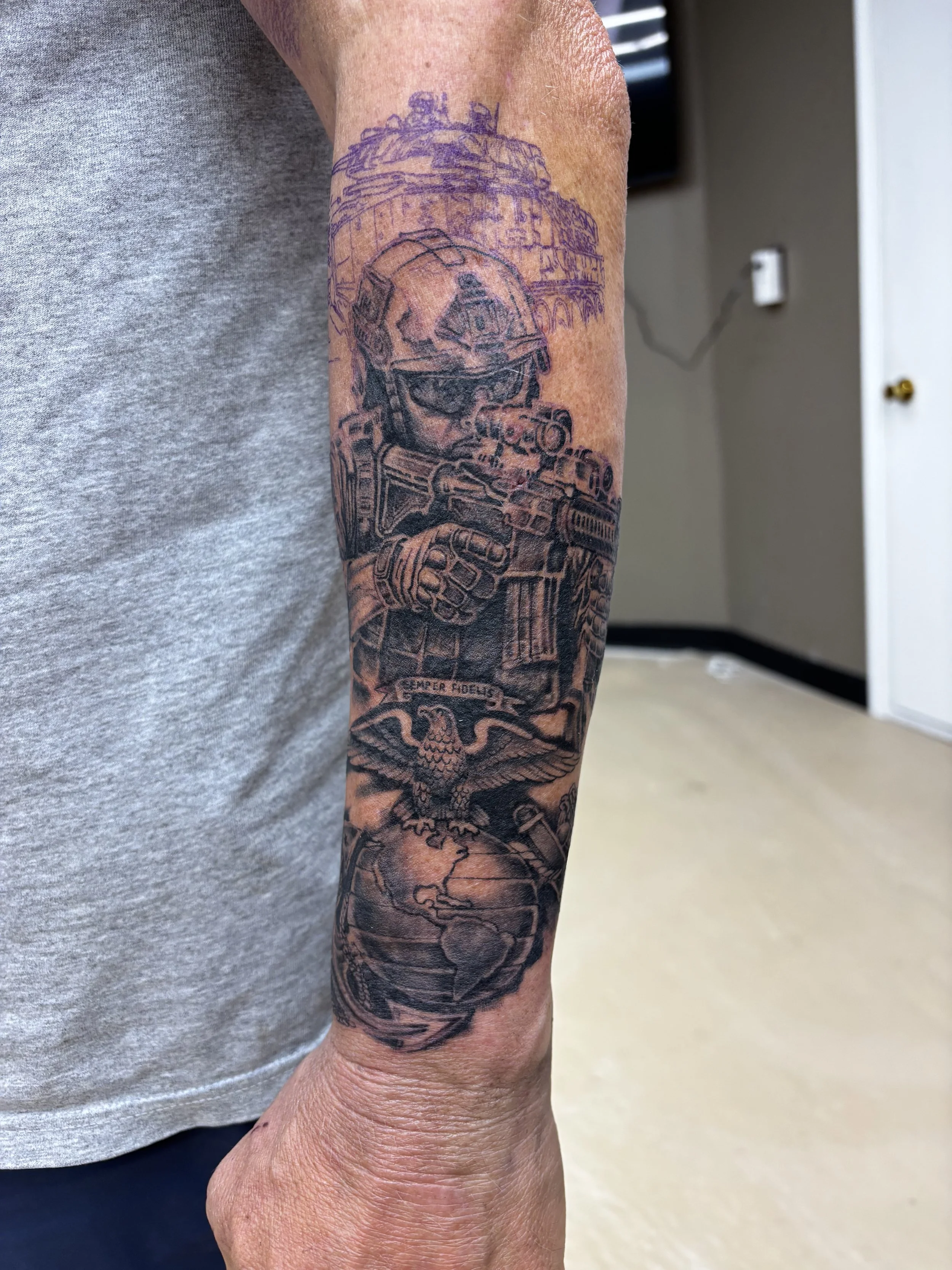 Black and grey realism marine core operator tattoo on a forearm by Altered Tattoo Co