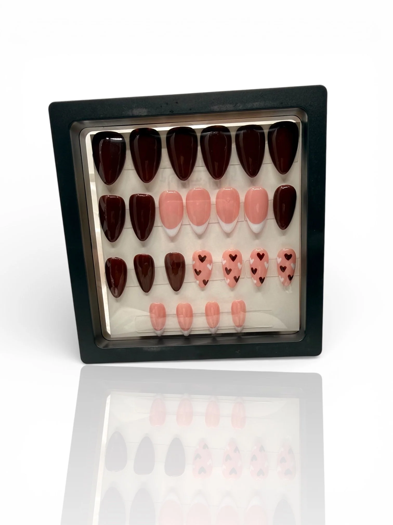 long Glossy chocolate brown almond-shaped press-on nails with pink French tips and black heart designs.