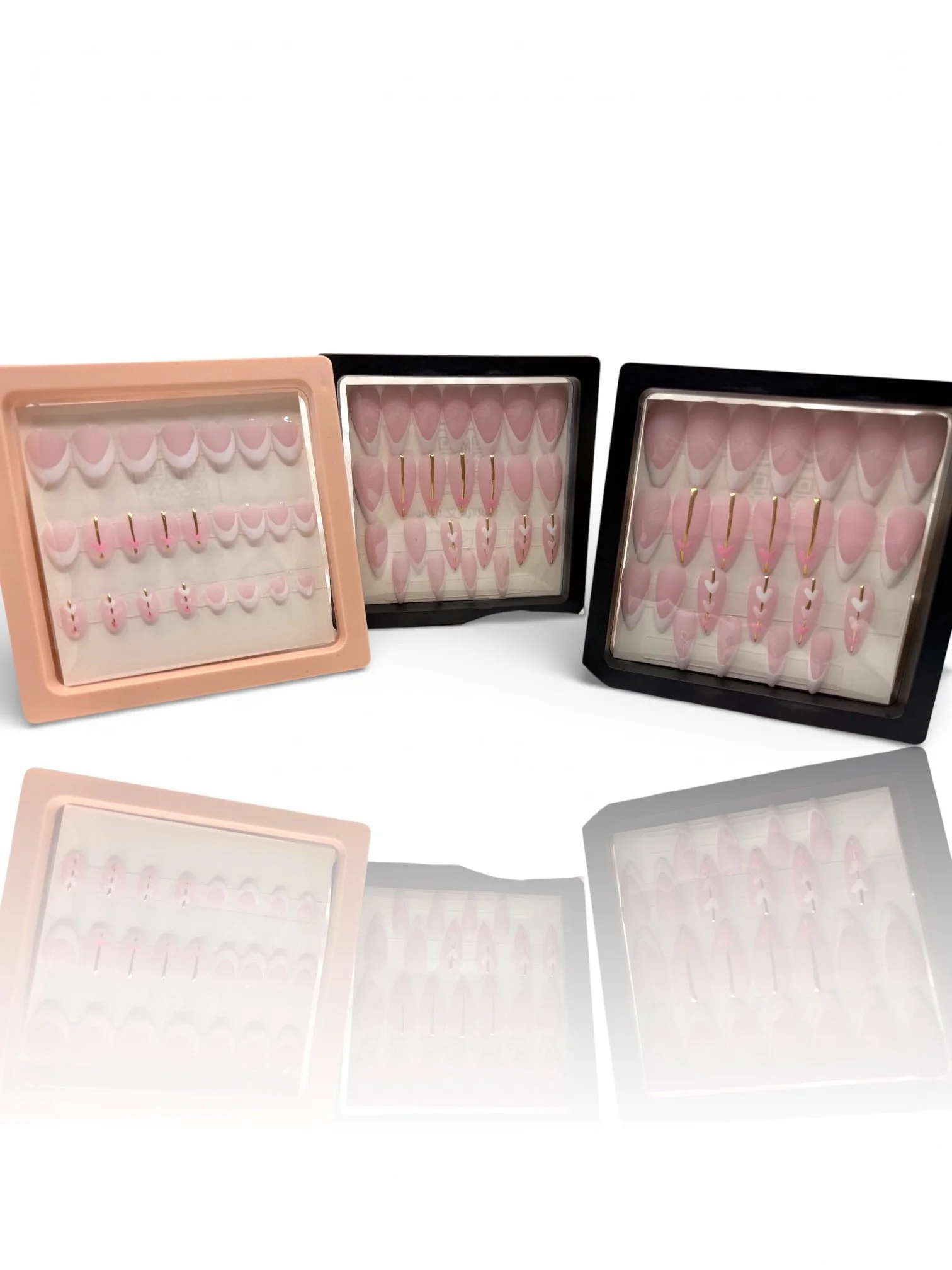 short Pink stiletto press-on nails with nude pink bases, French tips, gold accents, and delicate white heart designs.