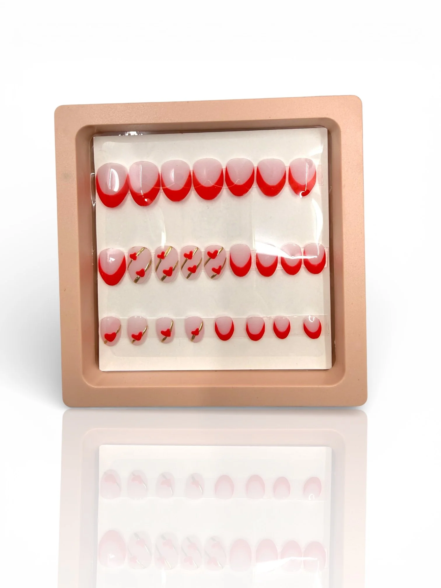 kids Matte stiletto press-on nails with nude pink bases, red V-shaped French tips, and delicate red heart designs.