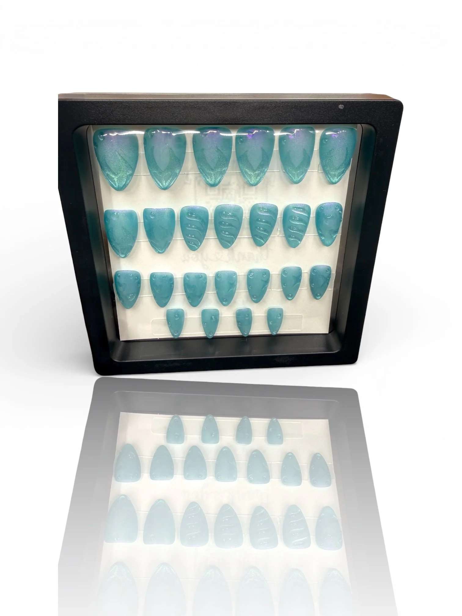 long Shimmering ocean blue almond-shaped press-on nails with mermaid-inspired scales, textured wave details, and an iridescent finish.
