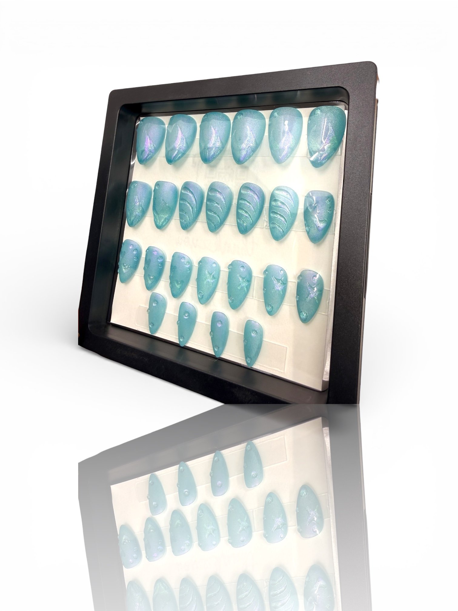 long Shimmering ocean blue almond-shaped press-on nails with mermaid-inspired scales, textured wave details, and an iridescent finish.