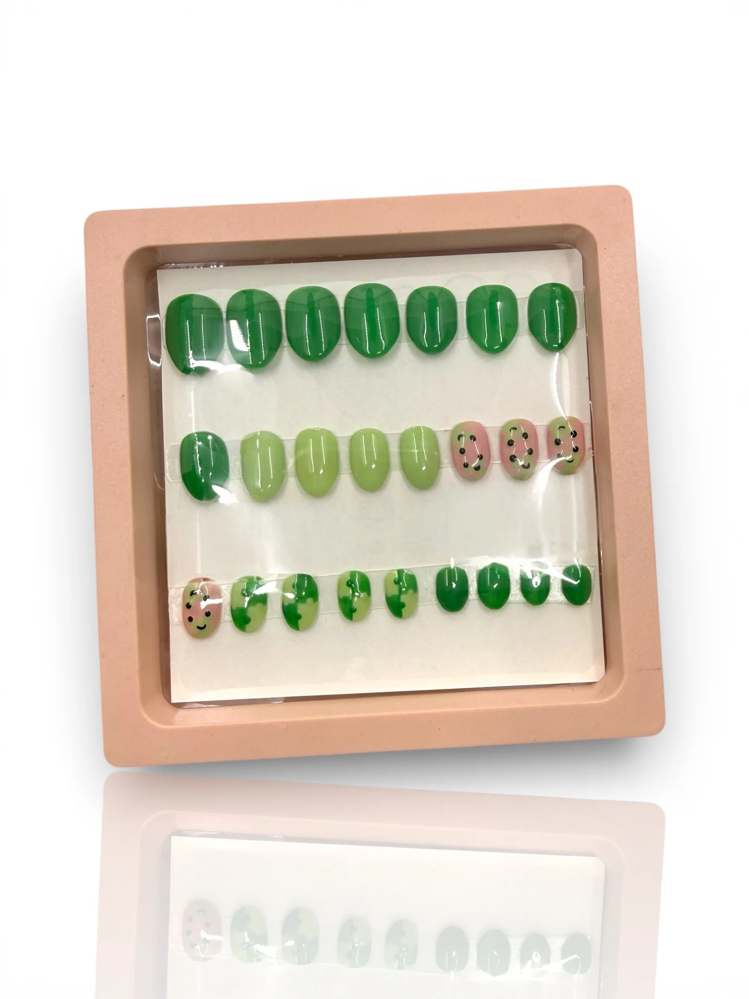 kids Green almond-shaped press-on nails with cute pink frog faces, lily pad designs, and glossy light and dark green accents.