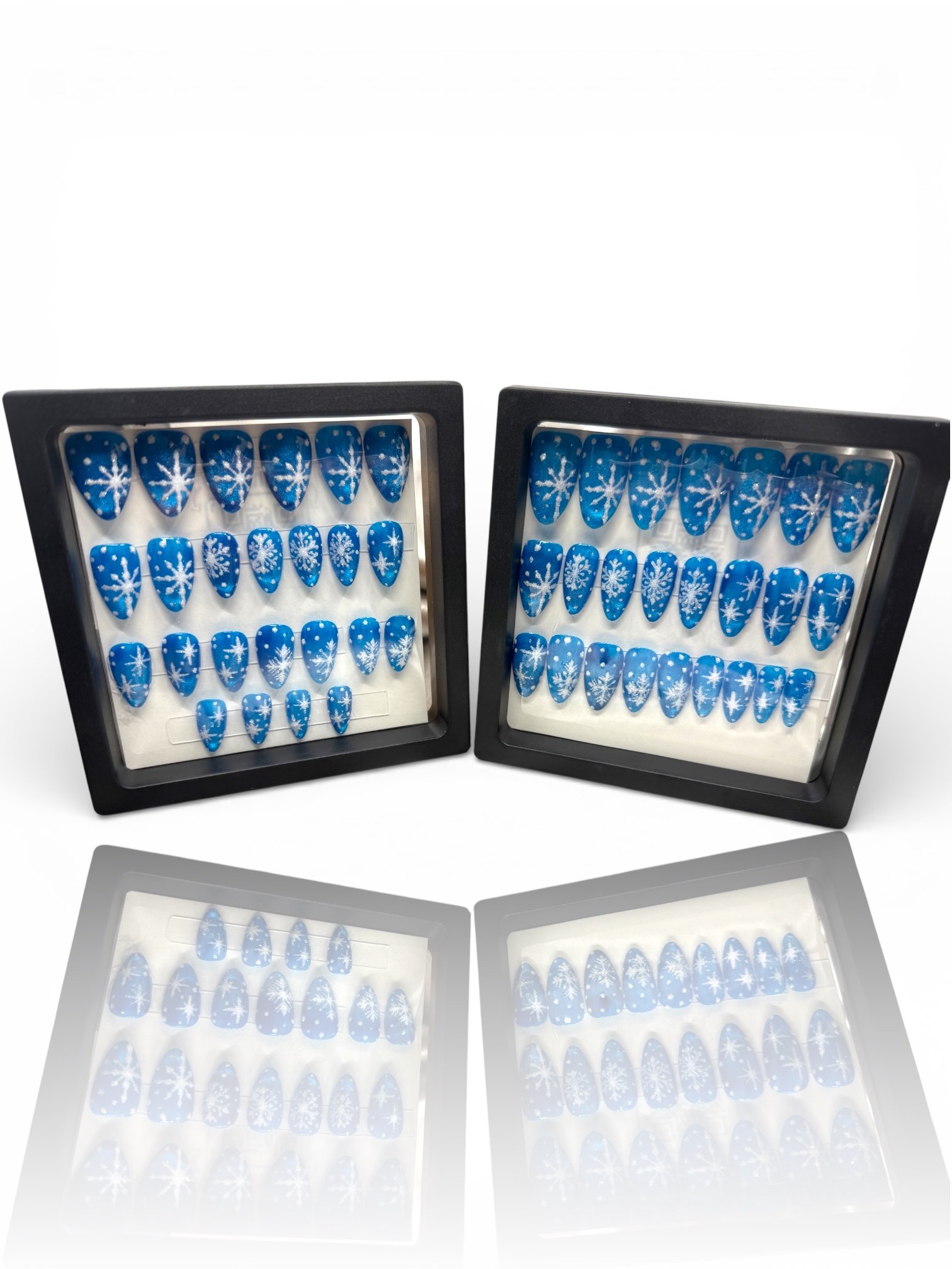 short Blue almond press-on nails with delicate white snowflakes and winter designs.