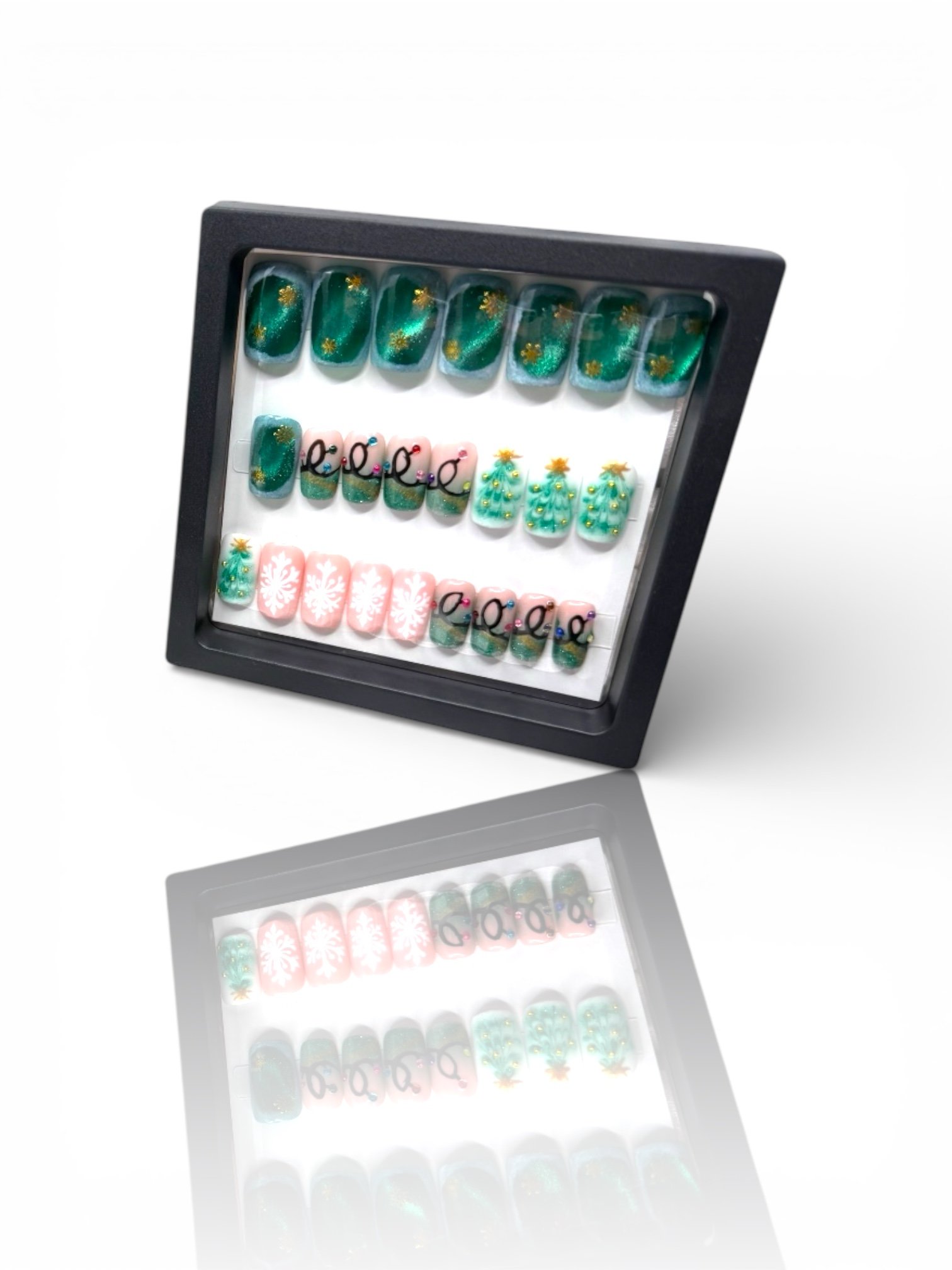 Green Christmas square press-on nails with gold accents, Christmas trees, pink snowflakes, and festive holiday nail art.