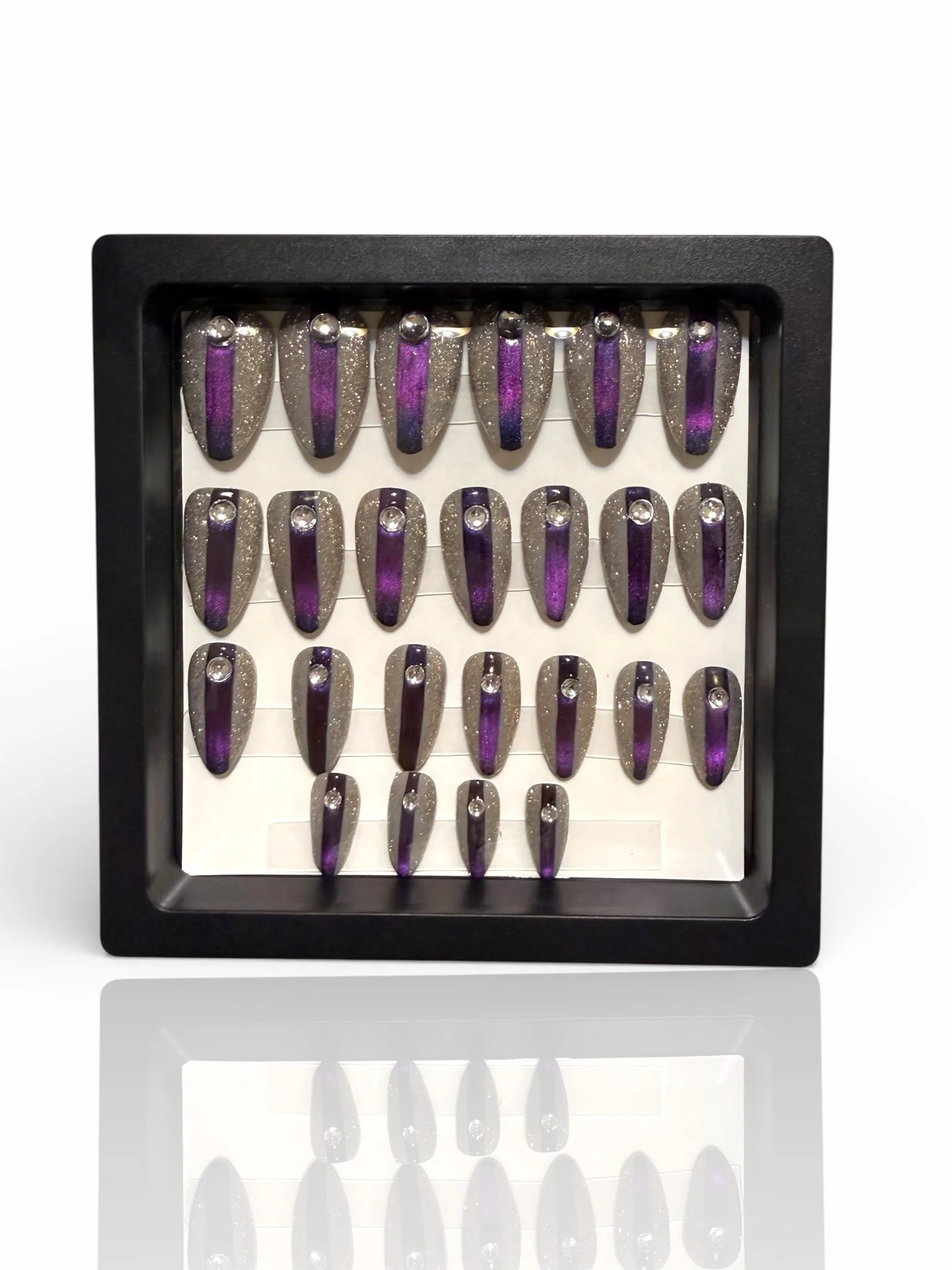 Purple almond cat eye press-on nails with silver glitter and rhinestone accents.