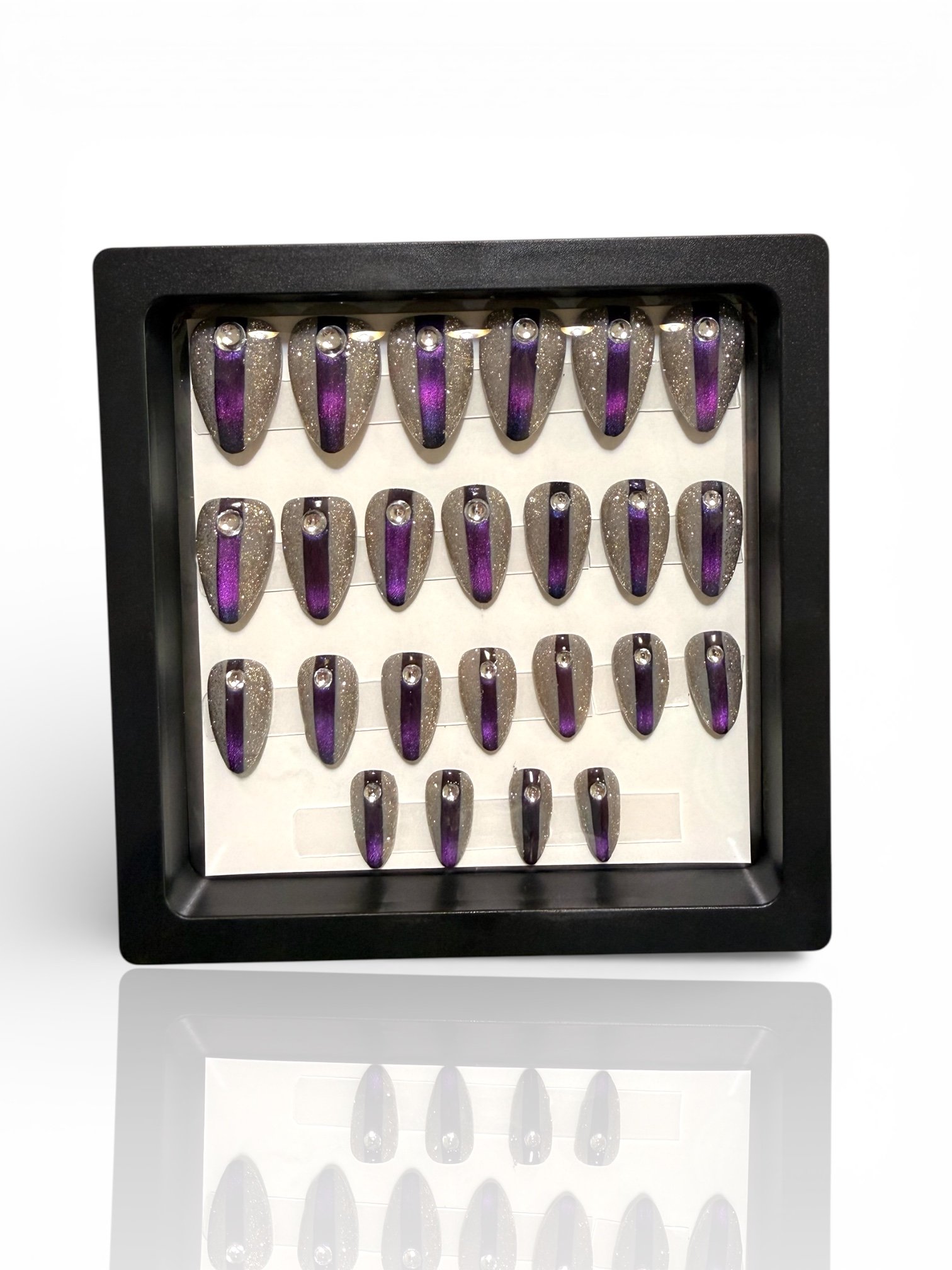 short Purple almond cat eye press-on nails with silver glitter and rhinestone accents.