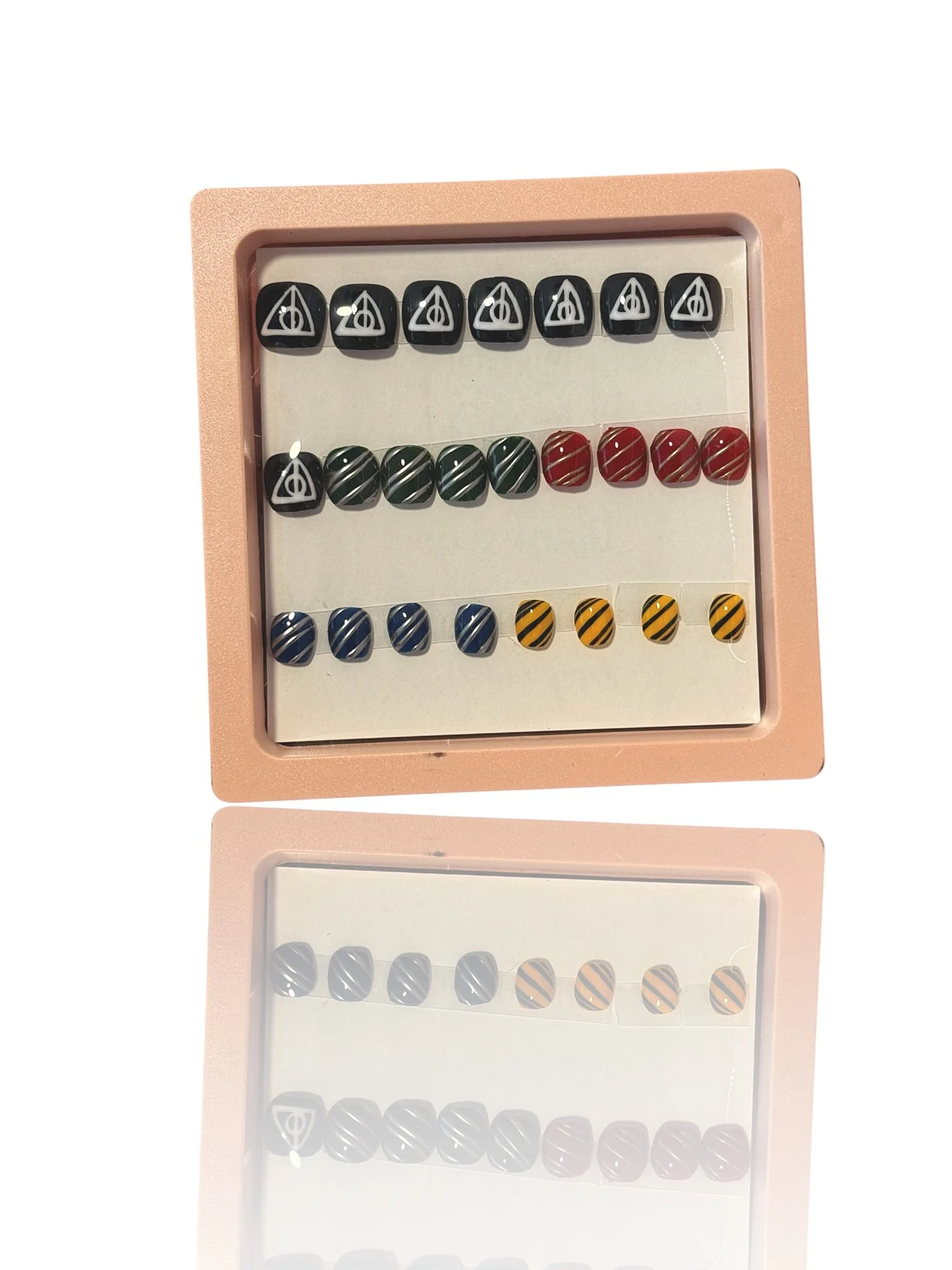 kids Harry Potter inspired coffin press-on nails featuring black Deathly Hallows symbols and red, green, blue, and yellow striped house designs.