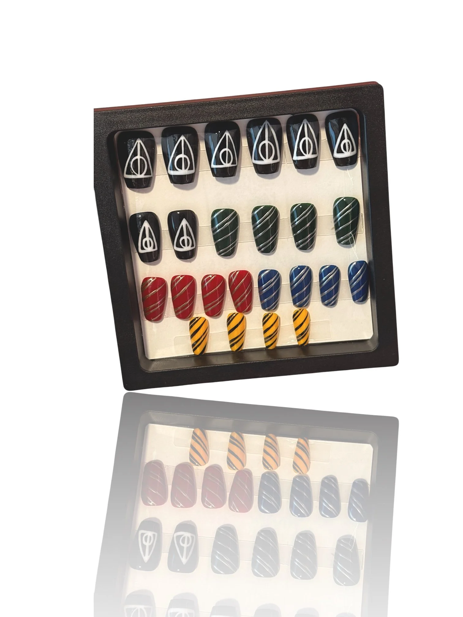 Harry Potter inspired coffin press-on nails featuring black Deathly Hallows symbols and red, green, blue, and yellow striped house designs.