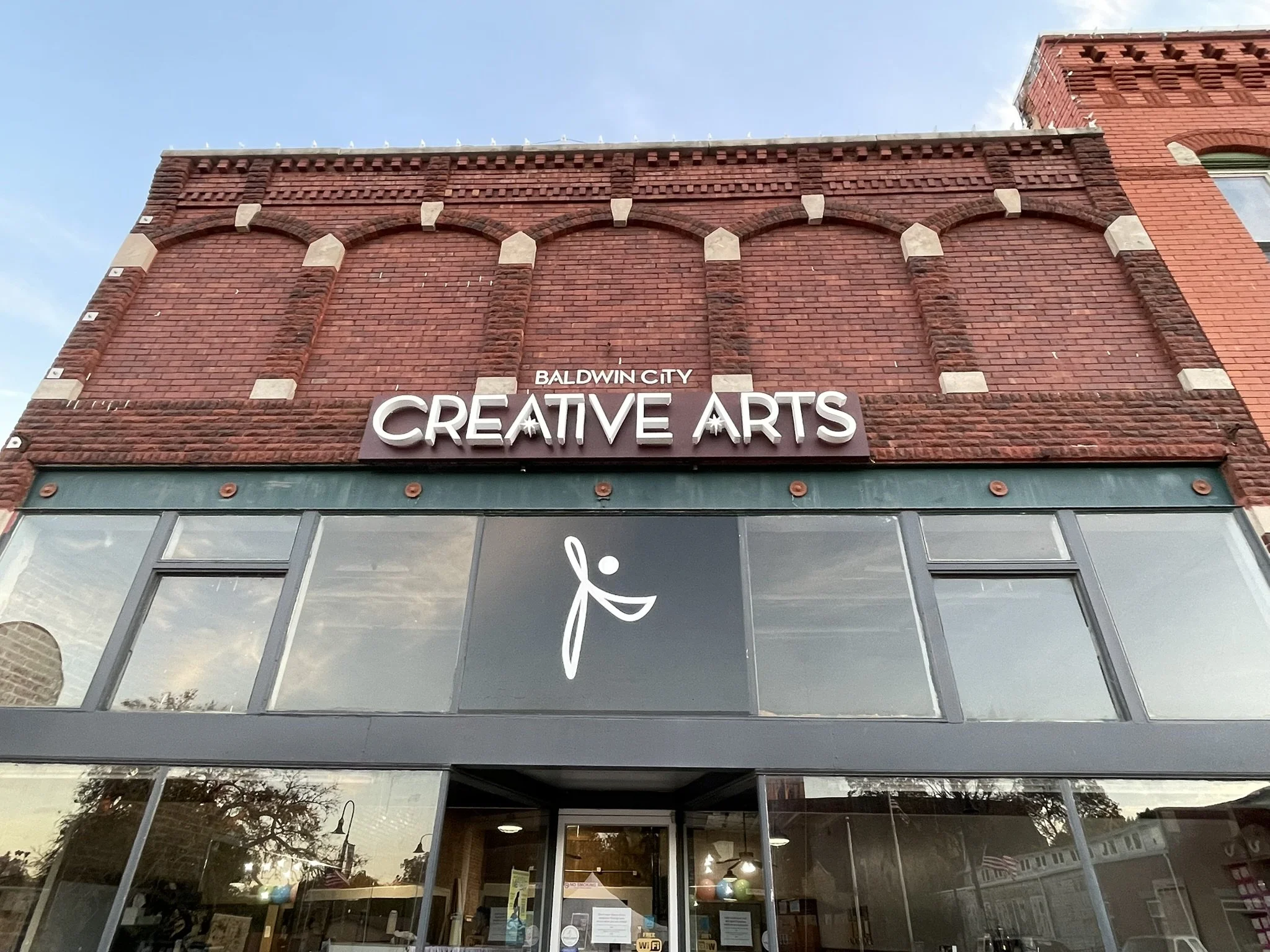A brick building with a sign that reads 'Baldwin City Creative Arts'.