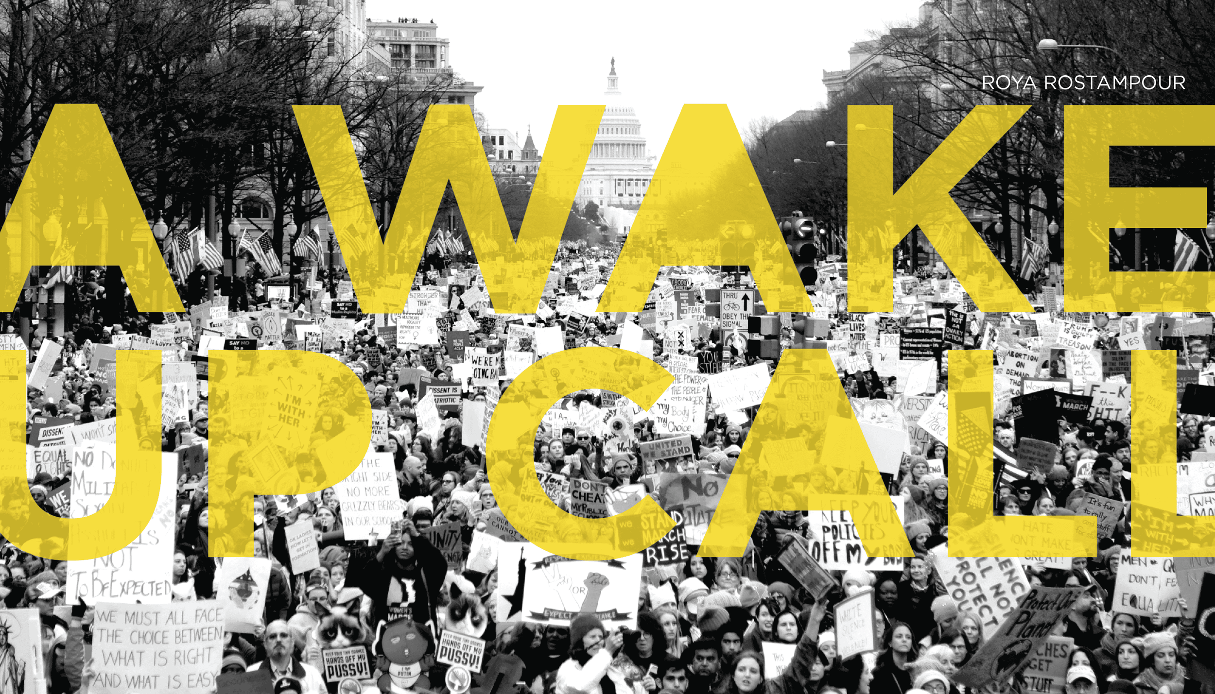 Black and white photo of a large crowd of protesters holding signs and banners, with the Capitol building in the background and trees lining the street.