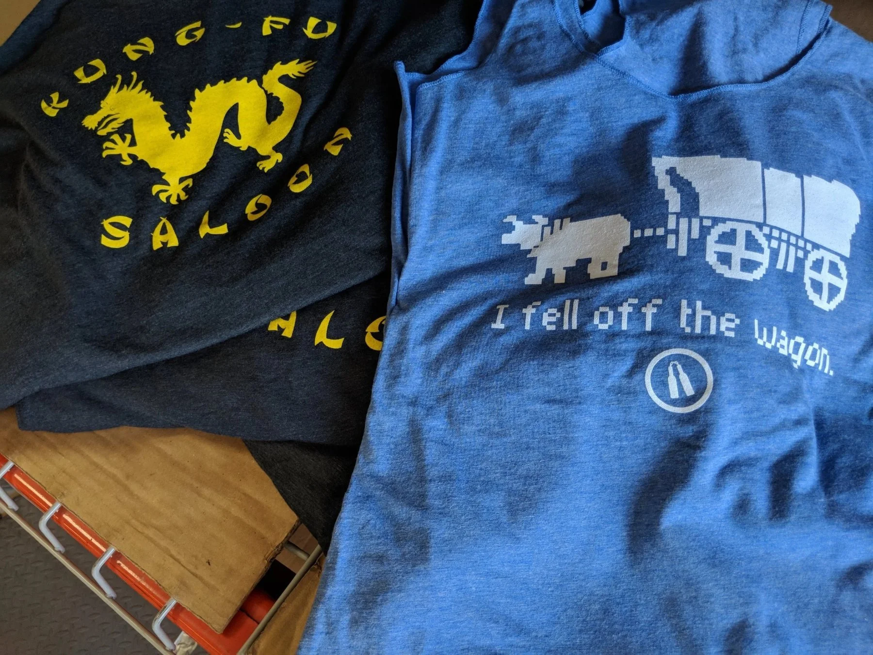 Custom screen printed shirts folded next to each other for Kung Fu Saloon Bar in Austin Texas.