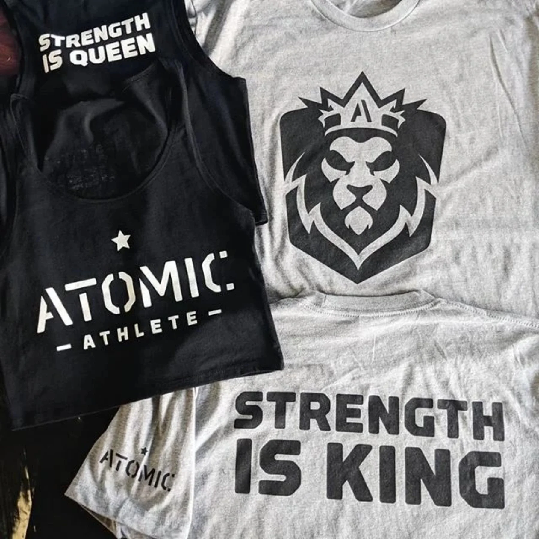 Stack of screen printed shirts and tank tops for Atomic Athlete gym in Austin, Texas.