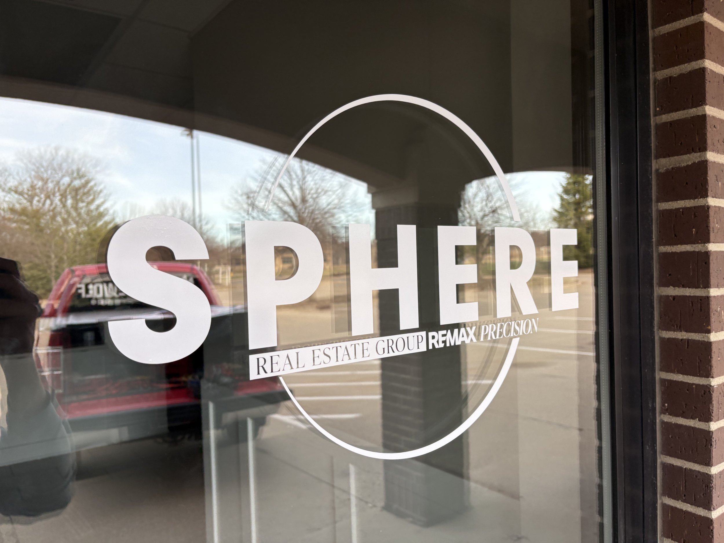 Front door window with the word 'SPEERE' in large white letters and branding for real estate companies.
