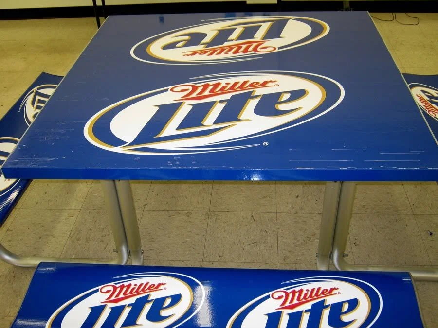 Table and bench with Miller Lite beer logo print in blue, white, and red colors.