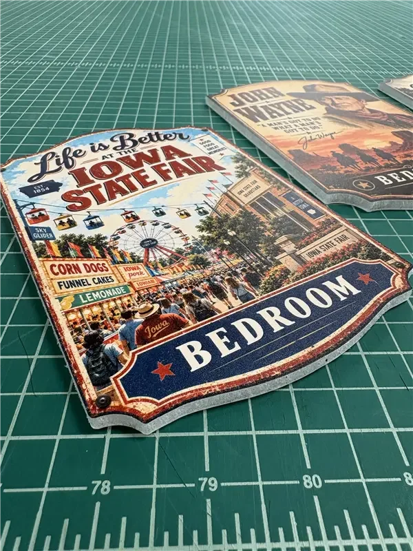 Colorful sign for the Iowa State Fair, featuring a Ferris wheel and food stalls, with the word "Bedroom" at the bottom.