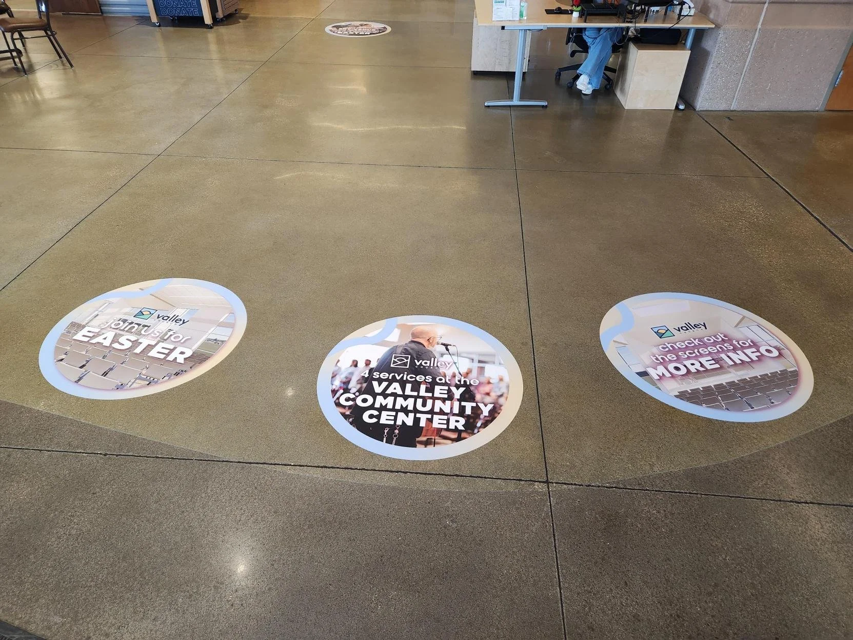 Floor stickers at Valley Community Center, promoting joining for Easter, services at Valley Community Center, and checking screens for more info.