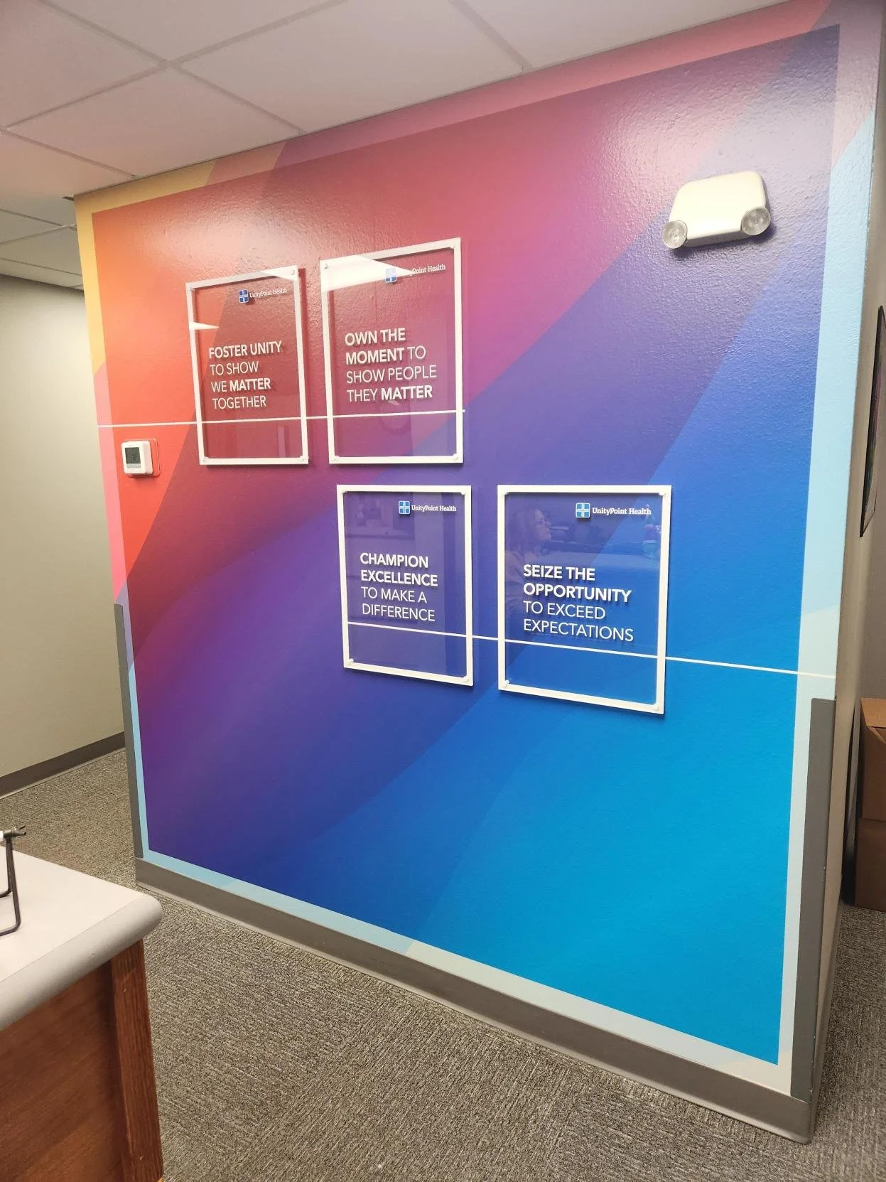 A colorful wall display with motivational messages from UnityPoint Health, including phrases about unity, ownership, excellence, and seizing opportunities.