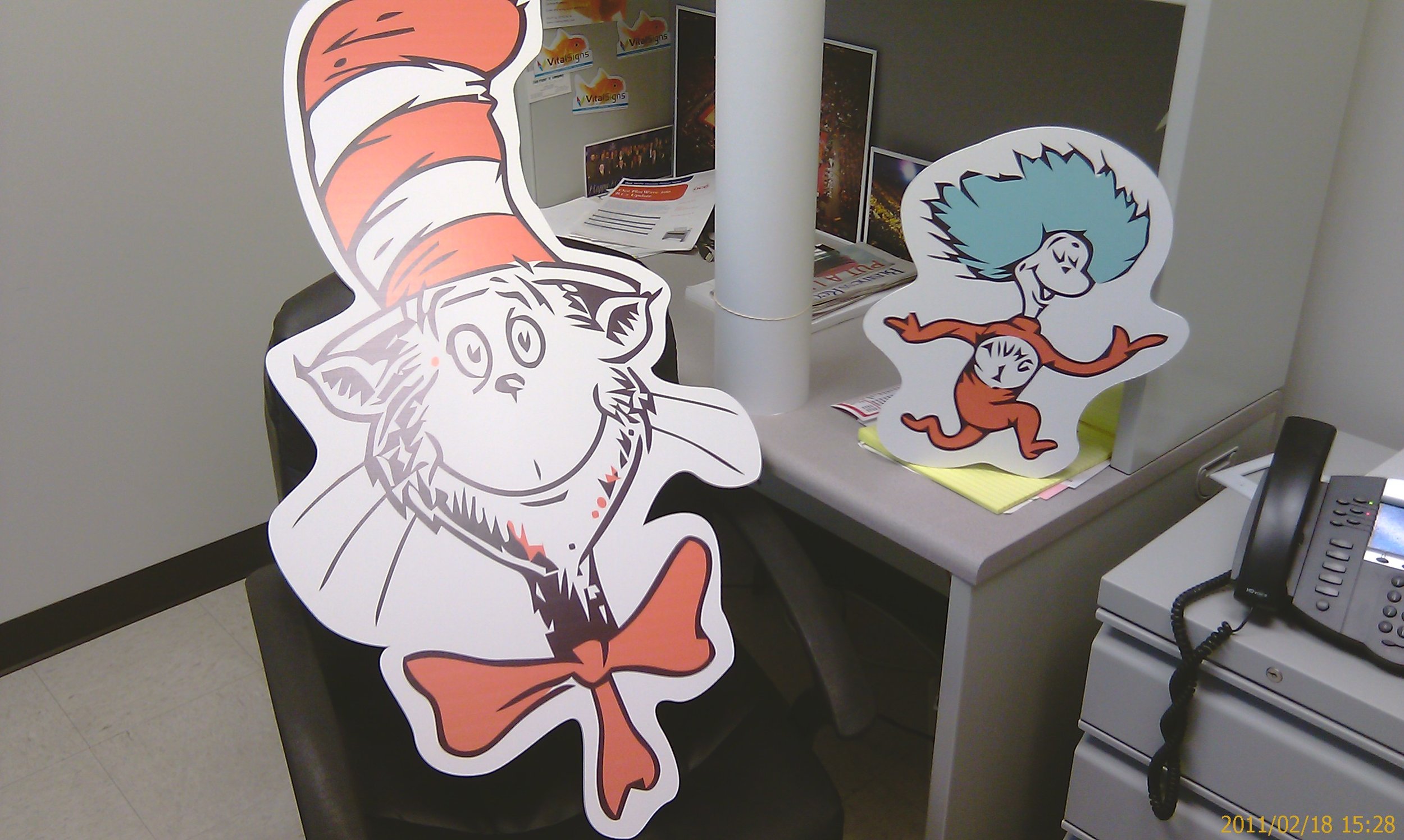 Decorative cutouts of the Cat in the Hat and Thing 1 from Dr. Seuss on a desk in an office.