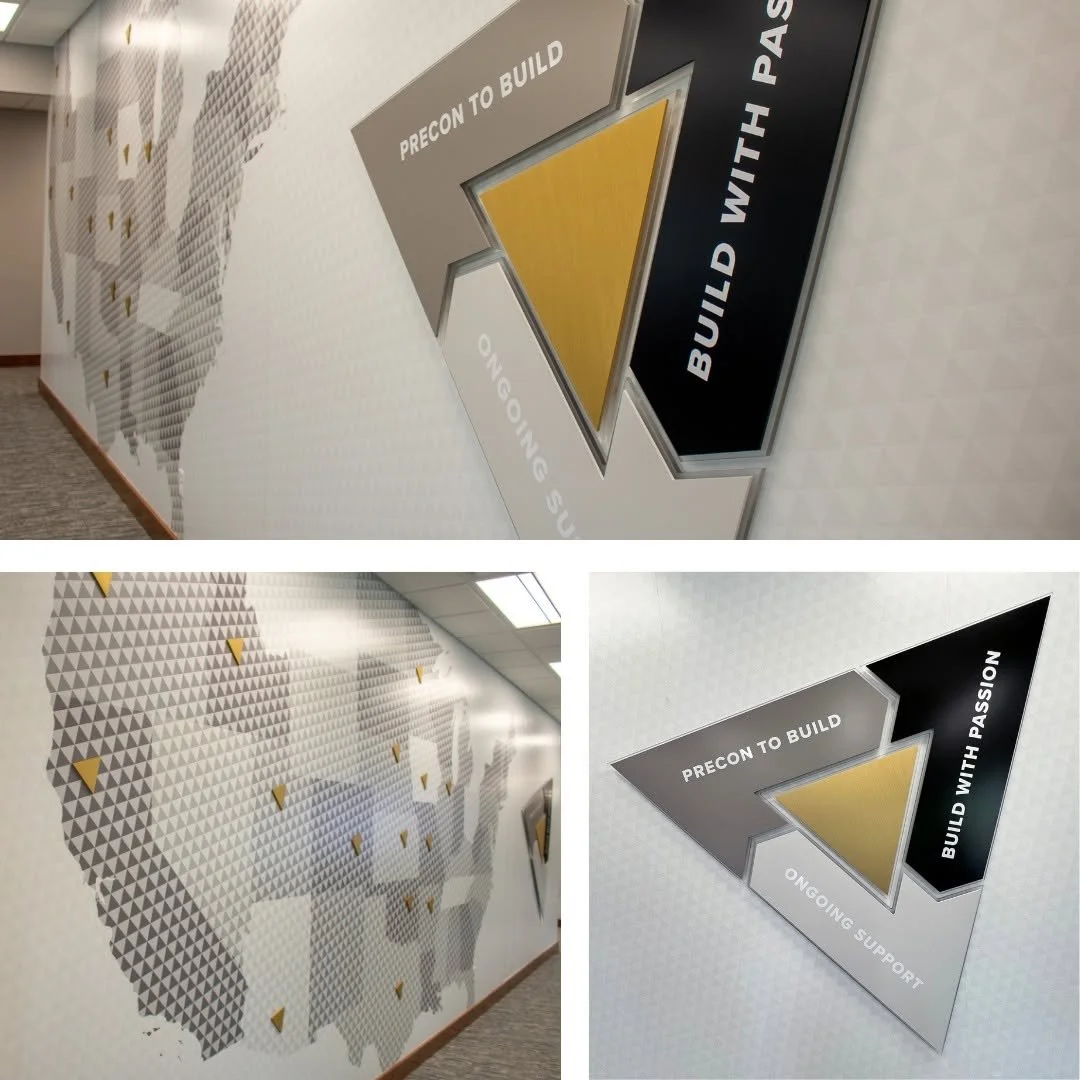 A wall with a map of the world made of gray triangular patterns and a large arrow sign with the words "Precon to Build," "Build with Passion," and "Ongoing Support."