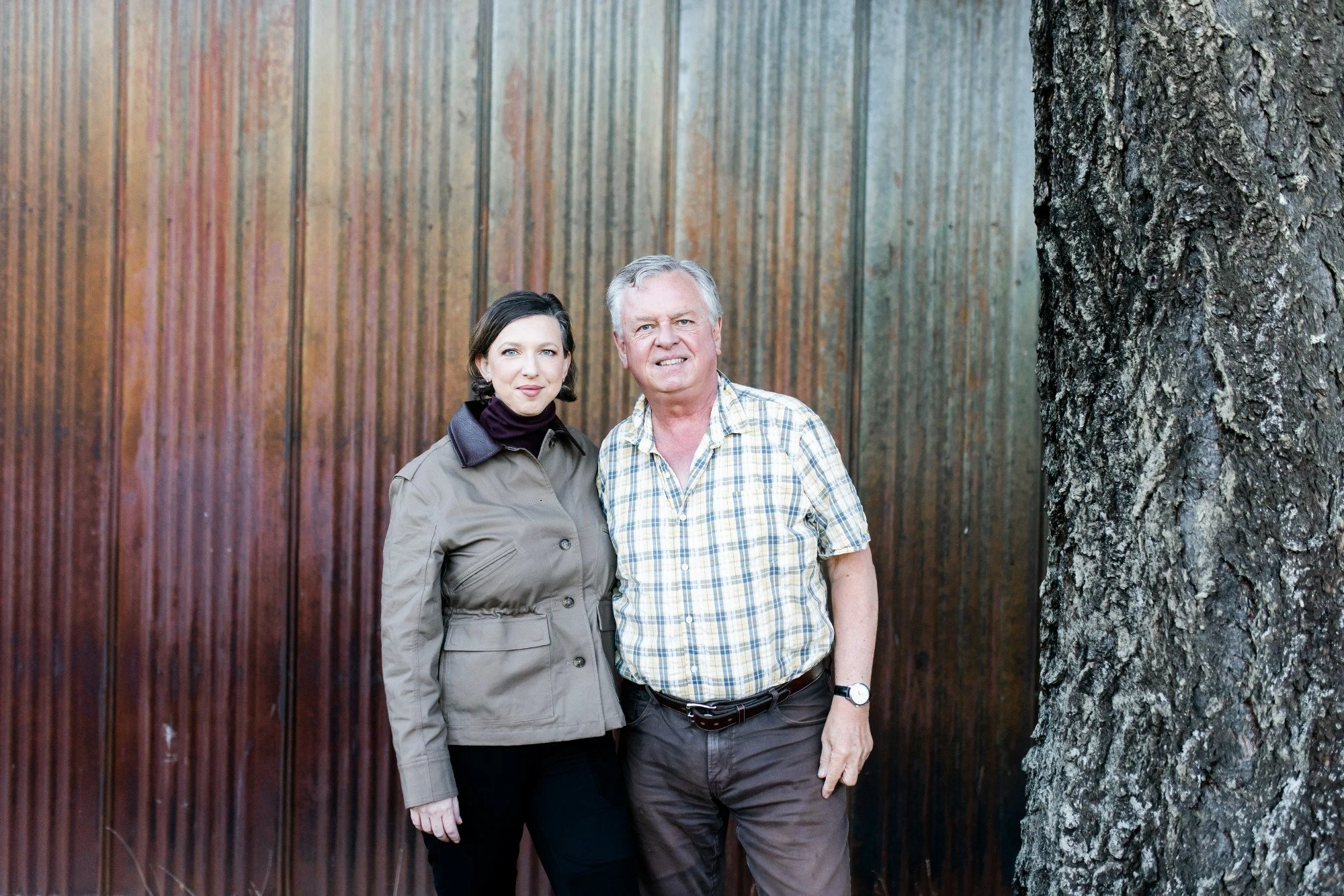 Kathryn and Chris Hermann in front of a weathered corrugated metal wall